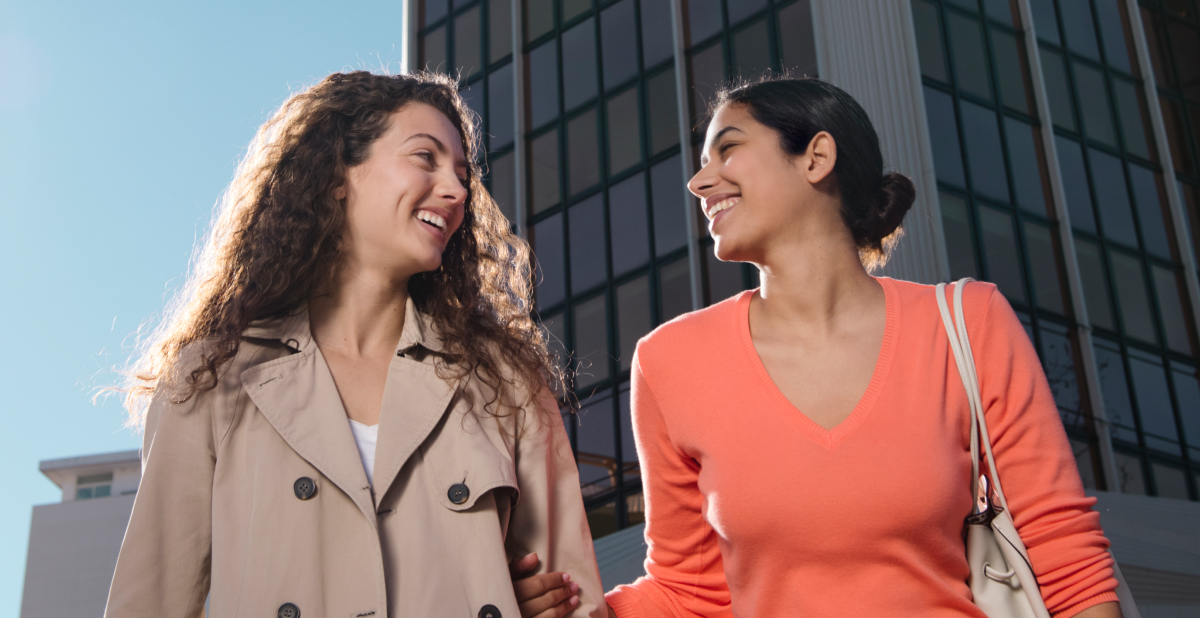 women outside smiling at each other 