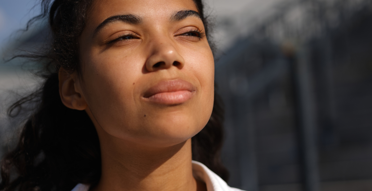 The connection between pollution and dark spots - woman looking in sun