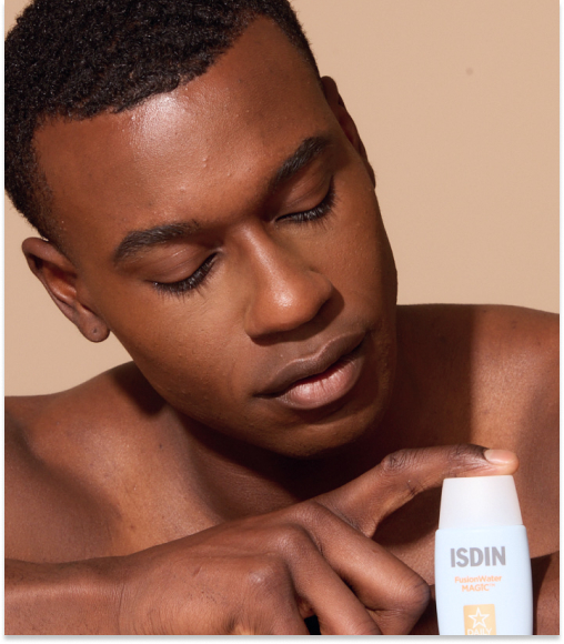 Man applying sunscreen from a bottle labeled "ISDIN Fusion Water MAGIC", highlighting skincare application.